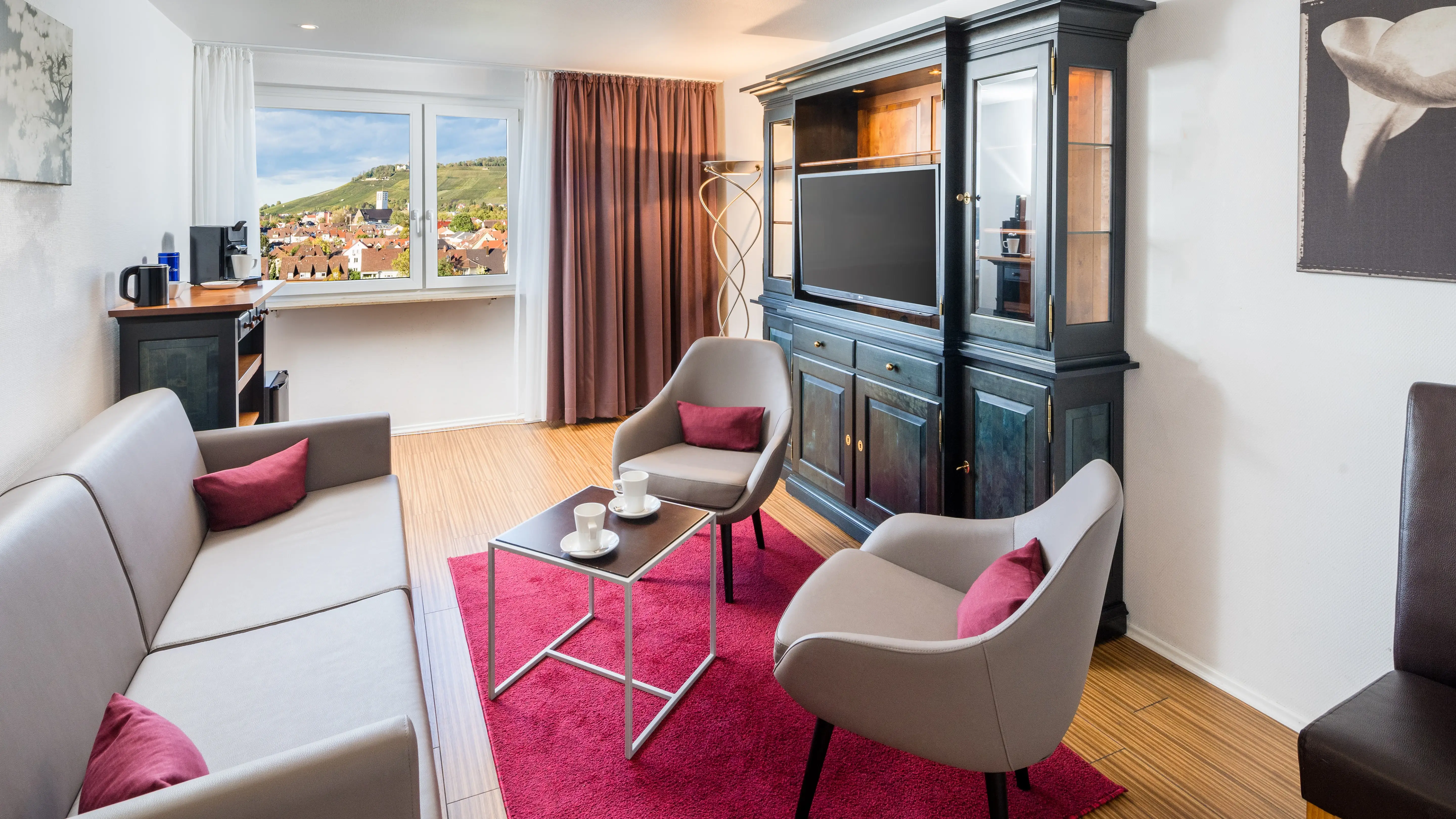 Moderne Hotelsuite mit gemütlicher Sitzecke, stilvollen Möbeln und viel Tageslicht